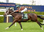 Jockey in green and red striped silks rides a galloping brown racehorse wearing number 4 saddlecloth, with Kensington signage in the background.