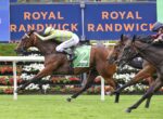 Horse race in progress at Royal Randwick; lead brown horse with green number 2 saddlecloth, rider in lime-green and white silks, other horses close behind against a backdrop that says ROYAL RANDWICK.