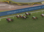 Group of racing horses with jockeys in bright silks sprinting on a green turf track; a blue advertising banner runs along the inside rail.